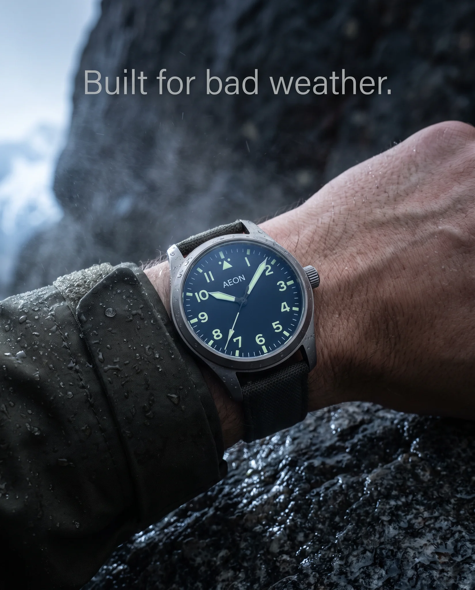 Example ad generated with terrads: AEON field watch on a rain-soaked wrist against dark rock, headline “Built for bad weather.”